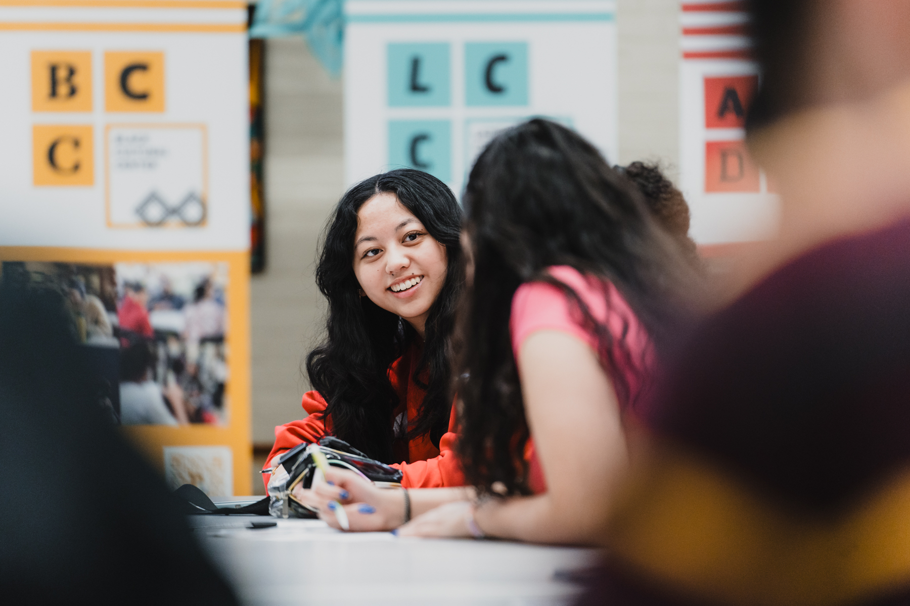 photo of a student smiling with the identity center banners in the background.