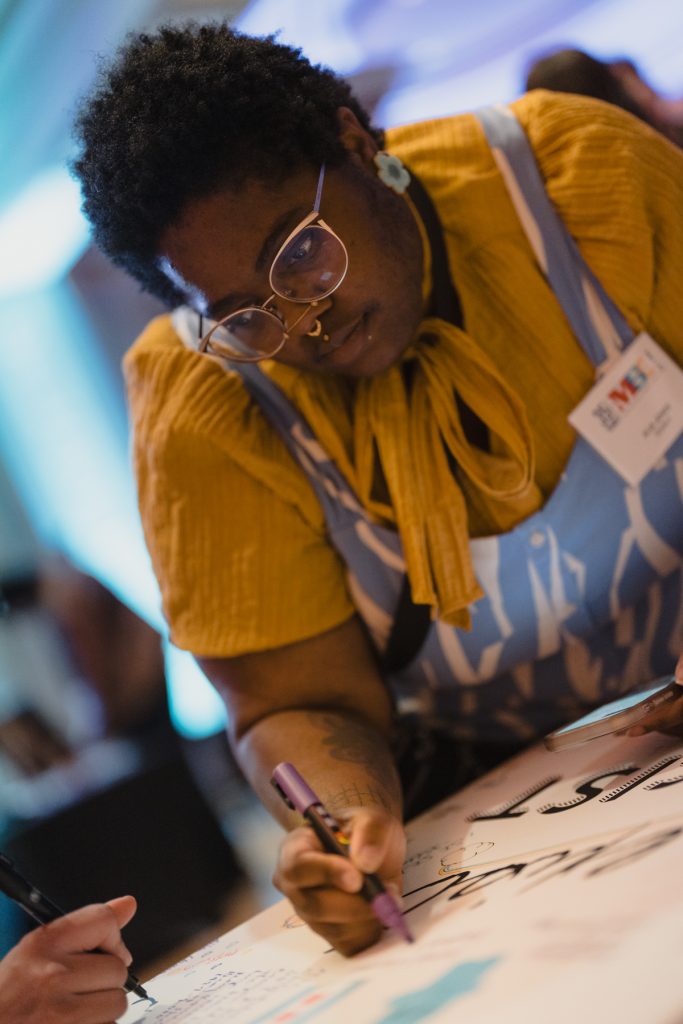 Attendees signing a poster