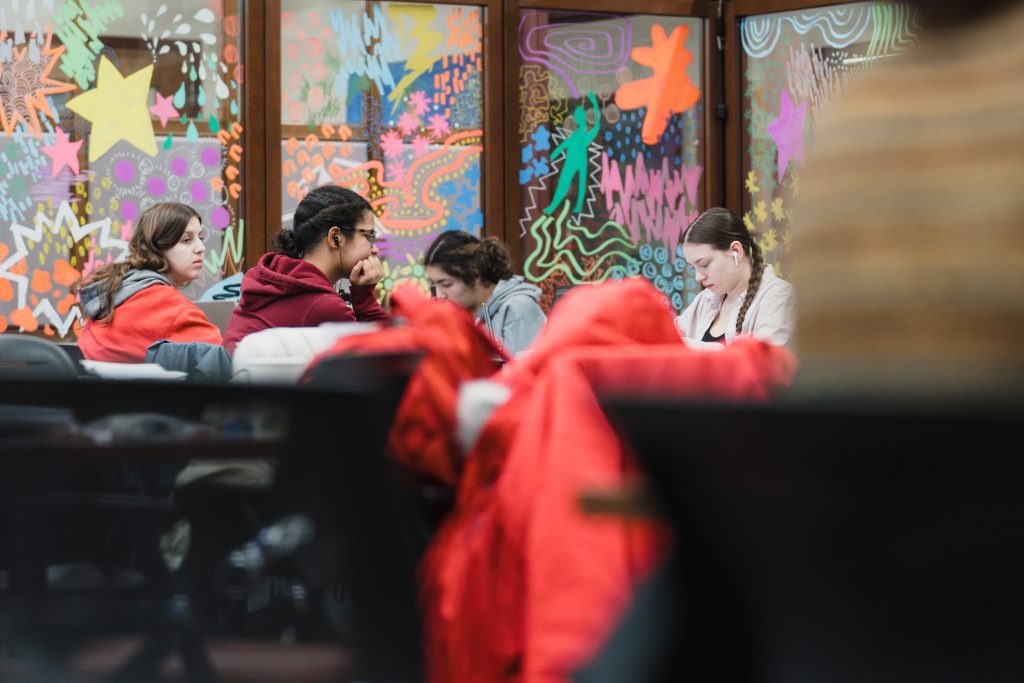 Photo of students studying with windows behind them.
