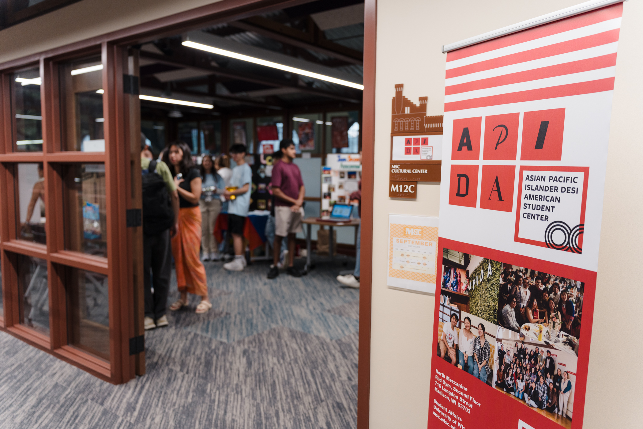 Outside of the APIDA Student Center, with students standing at tables inside the Center.