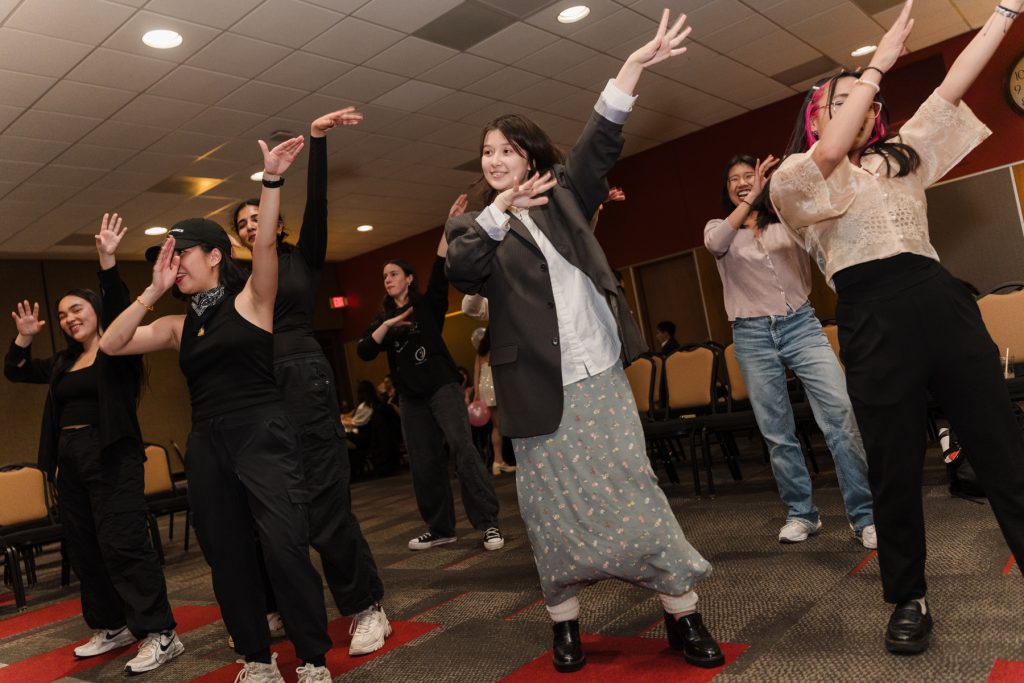 Students wave their hands as they dance.